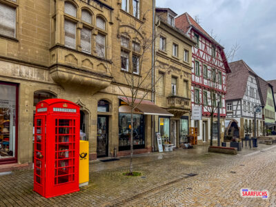 Rote britische Telefonzelle als markanter Kontrastpunkt vor historischer Fachwerkkulisse in Eppingen