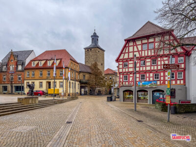Perspektive vom Rathausplatz auf den Pfeifferturm, eingerahmt von historischen Holzbalkenfassaden