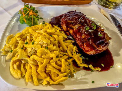 Ein Teller mit schw&auml;bischem Zwiebelrostbraten, geschmorten Zwiebeln und einer Portion Sp&auml;tzle in einer regionalen Gastst&auml;tte