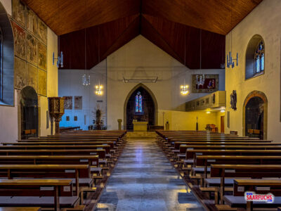 Blick in das moderne Kirchenschiff mit schlichter Bestuhlung und hohen W&auml;nden