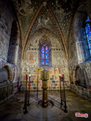Blick auf den historischen Altarraum mit gotischen Fresken und sakraler Kunst