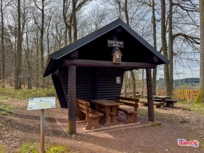 Schutzh&uuml;tte aus Holz mit Satteldach an einer Waldkreuzung