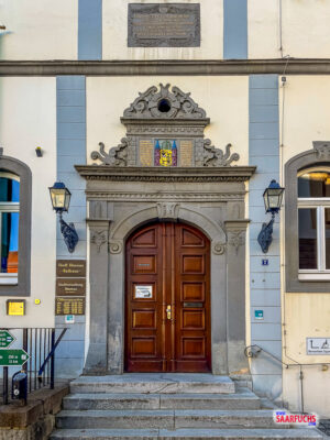 Detailaufnahme der historischen Holzeingangst&uuml;r des Rathauses mit dem steinernen Stadtwappen dar&uuml;ber