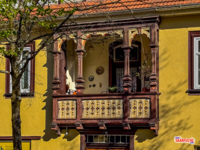 Detailansicht eines historischen, verzierten Holzbalkons an einer sanierten Fassade in der Ilmenauer Fu&szlig;g&auml;ngerzone