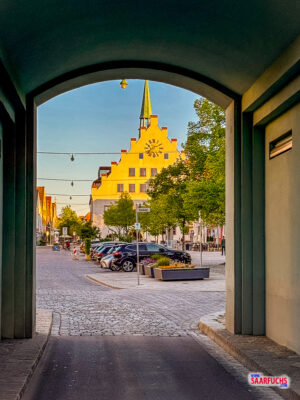 Perspektivischer Blick durch das Untere Tor auf das beleuchtete Neumarkter Rathaus