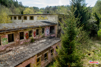 Blick aus einem Fenster im Dachgeschoss auf die verschiedenen, aneinandergrenzenden Dachstrukturen des Geb&auml;udekomplexes
