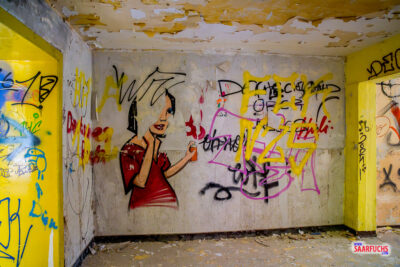Blick in ein betoniertes Treppenhaus des Lost Places, dessen W&auml;nde komplett mit bunten Graffiti bedeckt sind