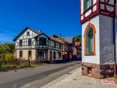 Blick durch eine gepflasterte Gasse in der Ortsmitte von Steinbach-Hallenberg mit traditionellen, eng stehenden Fachwerkh&auml;usern