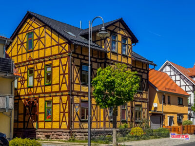 Restauriertes Fachwerkhaus mit detailreichen Holzverzierungen entlang der Hauptstra&szlig;e