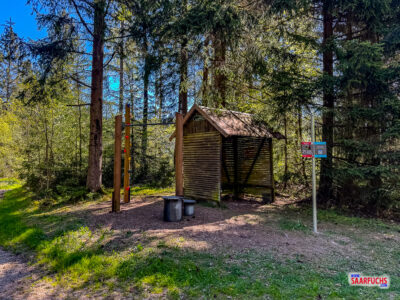 Nahaufnahme einer h&ouml;lzernen Fitnessstation im Wald mit einer versteckten Zahl f&uuml;r das Geocaching-R&auml;tsel