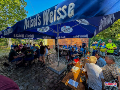 Gut besuchter Au&szlig;enbereich des Biergartens der Gastst&auml;tte G7 mit besetzten Holztischen