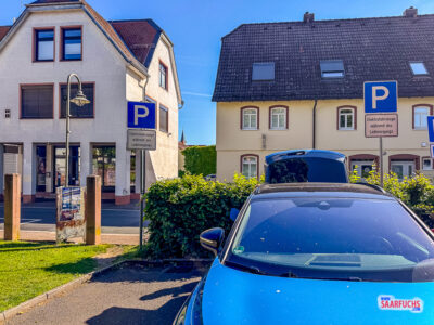 Nahaufnahme einem modernen Elektroauto beim Laden auf dem gepflasterten Rathausparkplatz in Friedrichsdorf