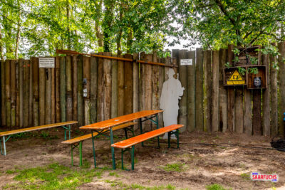 Außenbereich des Eventgeländes mit Holzbänken und Tischen