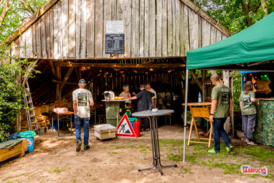 Innenansicht einer rustikalen Scheune, die mit Bierzeltgarnituren als wettergeschützter Aufenthaltsbereich eingerichtet ist