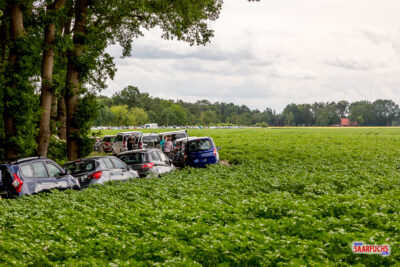 Mehrere am Rand eines unbefestigten landwirtschaftlichen Weges parkende Autos von Geocachern