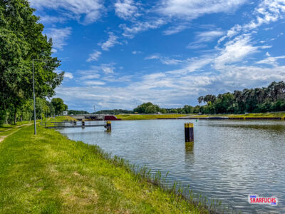 Blick auf den Dortmund-Ems-Kanal mit einem Uferweg unter leicht bewölktem Himmel