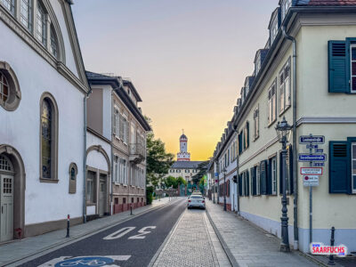 Blick von einer Seitenstraße auf den freistehenden Weißen Turm des Schlosses Bad Homburg