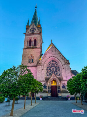 Die beleuchtete Fassade der katholischen Sankt-Marien-Kirche in der abendlichen Innenstadt von Bad Homburg