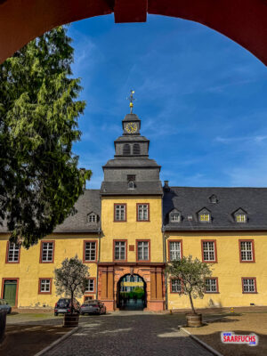 Blick durch einen großen Torbogen des Schlosses hinaus