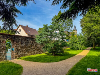 Ein kleiner steinerner Durchgang in der Schlossmauer führt direkt in eine schmale Pflasterstraße der Altstadt
