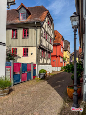 Eine schmale Gasse mit historischen, gut erhaltenen Fachwerkhäusern mit dunklem Balkenwerk