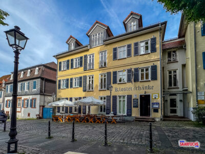 Außenbestuhlung der Klosterschänke direkt auf dem historischen, kopfsteingepflasterten Schlossplatz vor der alten Hausfassade