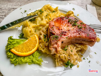 Ein deftiges gegrilltes Rippchen serviert mit einer Portion Sauerkraut und hausgemachtem Kartoffelpüree