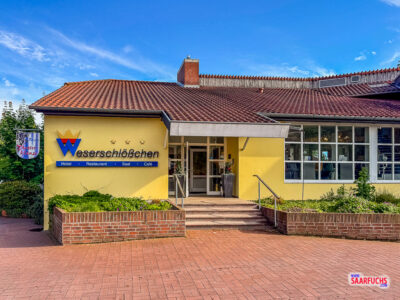 Außenansicht des Hotels Weserschlößchen direkt am Weserufer in Nienburg