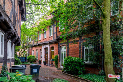 Enge, kopfsteingepflasterte Altstadtgasse flankiert von historischen roten Backsteinhäusern in Nienburg
