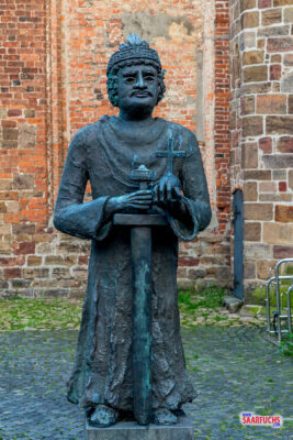 Monumentale Bronzestatue von Karl dem Großen mit Reichsapfel und Schwert vor der Kirche