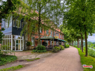 Außenansicht des Hasbergschen Hofs in Nienburg mit dem kleinen Biergarten im Eingangsbereich direkt an der Weser