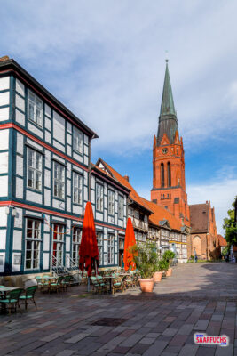 Blick über den gepflasterten Nienburger Marktplatz auf die historische Backsteinkirche St. Martin