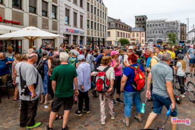 Viele Geocacher treffen sich bei einem Event neben einem Eiscafés in der Trierer Altstadt