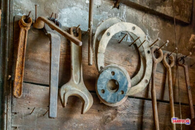 An der Wand montierte historische Handwerkzeuge und Maschinenteile in der alten Schmiede
