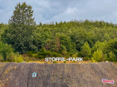 Aussichtspunkt mit Blick auf den großen weißen Stöffel-Schriftzug an den Steinbruchfelsen
