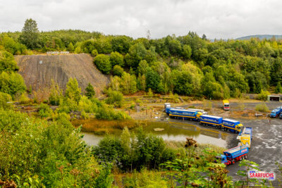Der Stöffelsee mit spiegelndem Wasser am Fuße der steilen Steinbruchwände