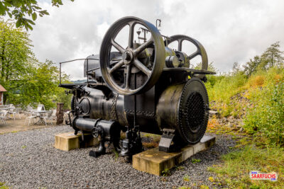 Imposante historische Dampfmaschine in schwarzer Lackierung auf dem Freigelände