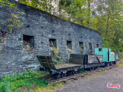 Eine historische kleine Feldbahn-Lokomotive auf Schienen im Basaltpark