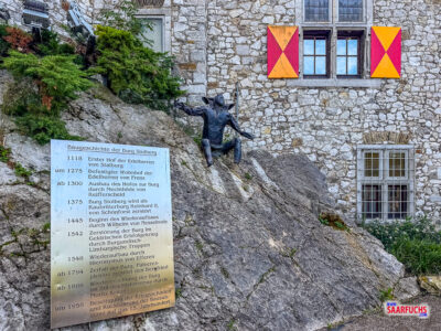 Informationstafel zur Burggeschichte am Felsen unterhalb des Bergfrieds
