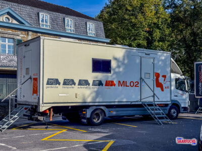 Parkplatz mit Garderobenwagen und Dreharbeiten-Equipment für den Film Der Buchspazierer