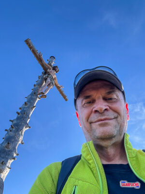 Selbstportr&auml;t am Gipfelkreuz des Hinteren H&ouml;rnles mit Bergkulisse im Hintergrund