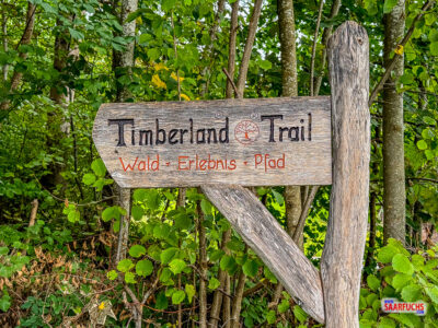 Beschilderung und Einstieg zum Erlebnispfad Timberland Trail am Ortsrand