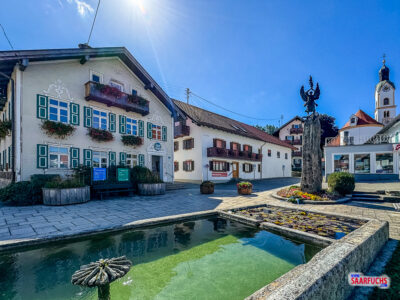Der idyllische Dorfbrunnen vor dem traditionellen Rathaus in Bad Kohlgrub